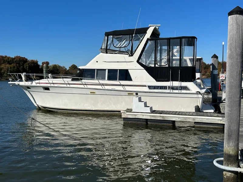 The Image of 1990 Silverton AFT CABIN yacht docked at marina on a sunny day. - 1