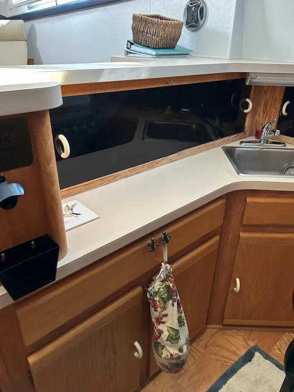 Slide: The Image of 1990 Silverton AFT CABIN kitchen with wooden cabinets and sink. - 11