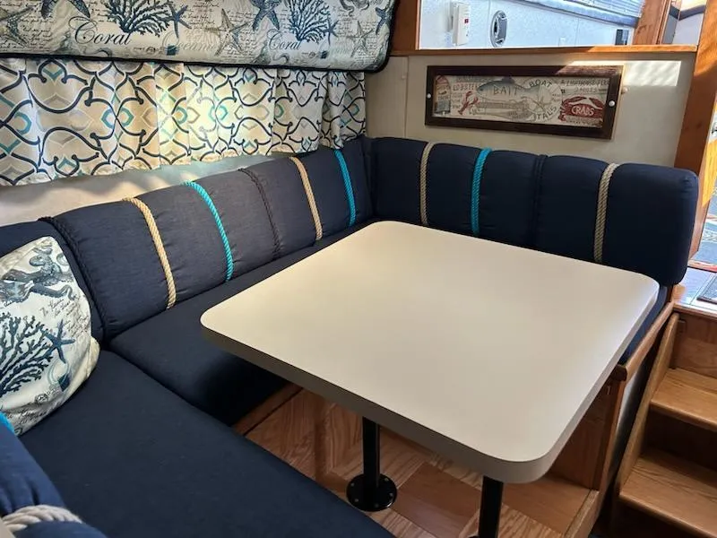 Slide: The Image of 1990 Silverton AFT CABIN interior with cozy dining area and nautical-themed decor. - 12