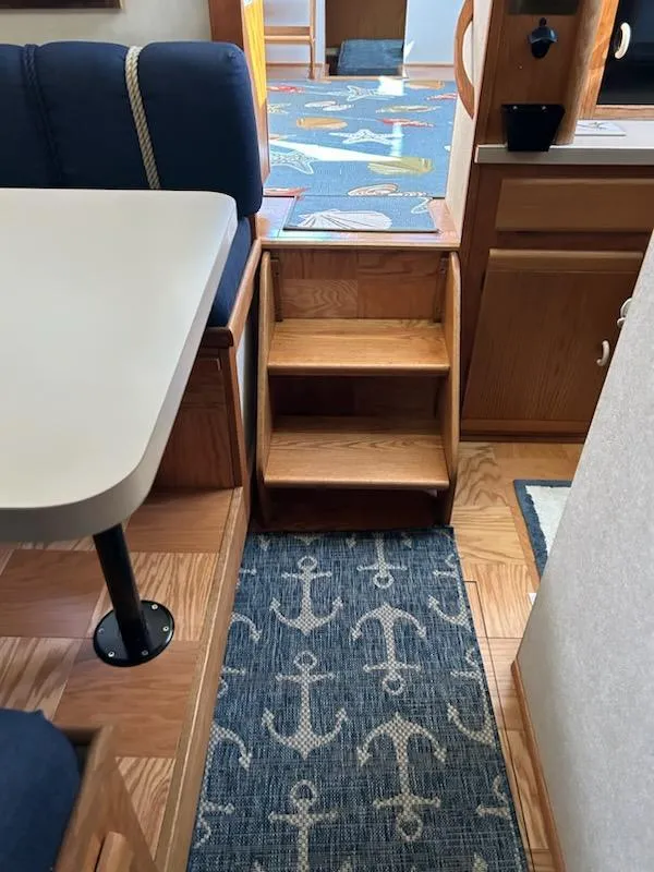 Slide: The Image of 1990 Silverton AFT CABIN interior with wooden steps and nautical-themed decor. - 14
