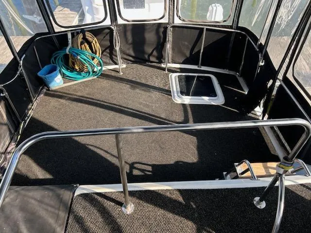 Slide: The Image of 1990 Silverton AFT CABIN boat deck with railing, hose, and hatch. - 17