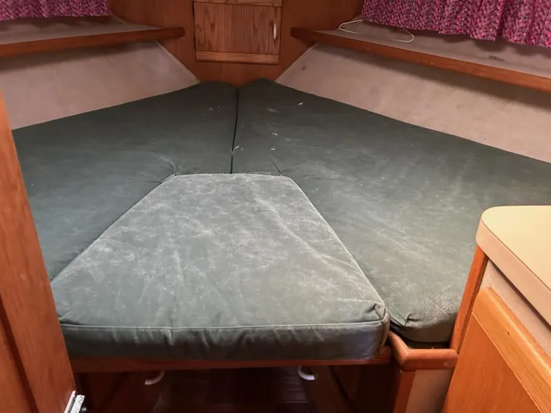 Slide: The Image of 1990 Silverton AFT CABIN boat interior with green cushioned bed and wooden cabinetry. - 19