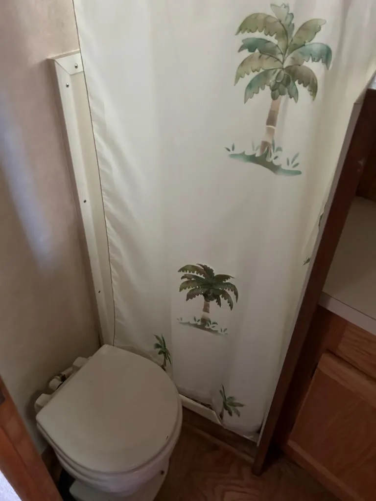 Slide: The Image of 1990 Silverton AFT CABIN bathroom with palm tree shower curtain. - 20