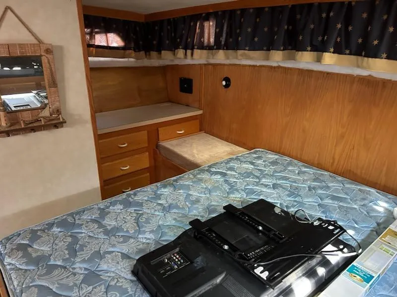 Slide: The Image of 1990 Silverton AFT CABIN bedroom with mattress, drawers, and mirror. - 21