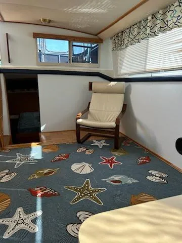 Slide: The Image of 1990 Silverton AFT CABIN interior with nautical-themed carpet and comfortable seating. - 4