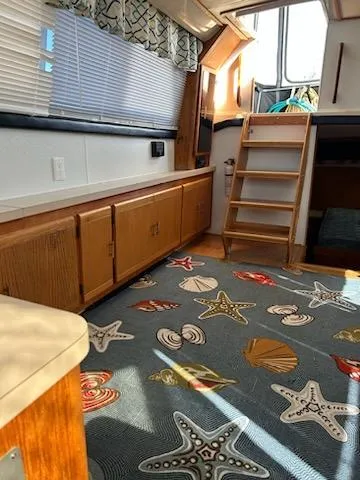 Slide: The Image of 1990 Silverton AFT CABIN interior with nautical-themed decor and wooden cabinetry. - 7