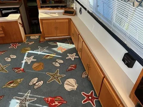 Slide: The Image of 1990 Silverton AFT CABIN interior with nautical-themed carpet and wooden cabinetry. - 8