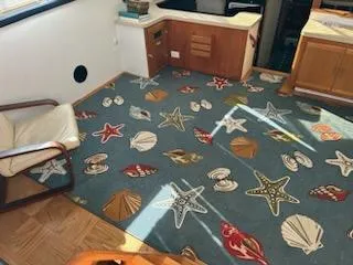 Slide: The Image of 1990 Silverton AFT CABIN interior with nautical-themed carpet and wooden cabinetry. - 9