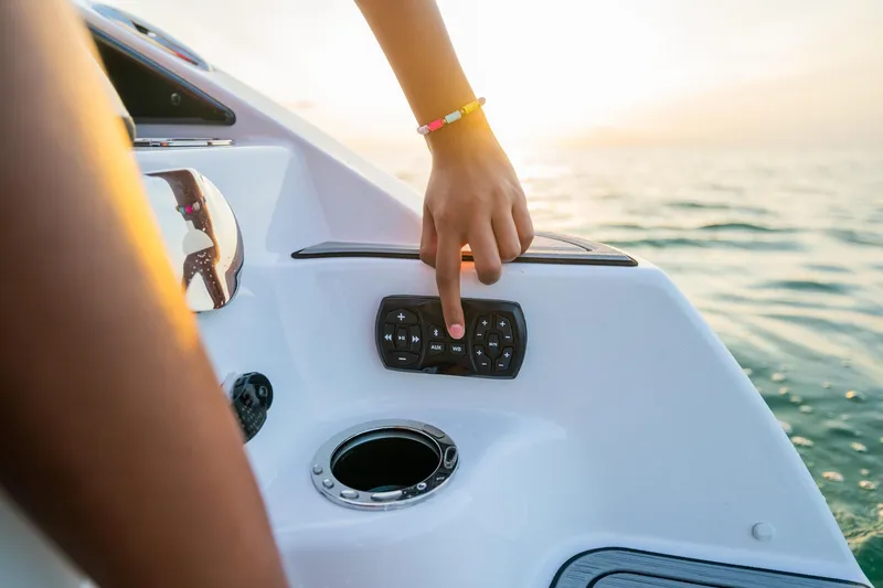 Slide: The Image of Hand operating control panel on 2024 Yamaha Boats 252S at sunset. - 7