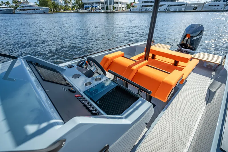 Slide: The Image of 2024 Goldfish 28 Tender boat with orange seating and modern dashboard on the water. - 10