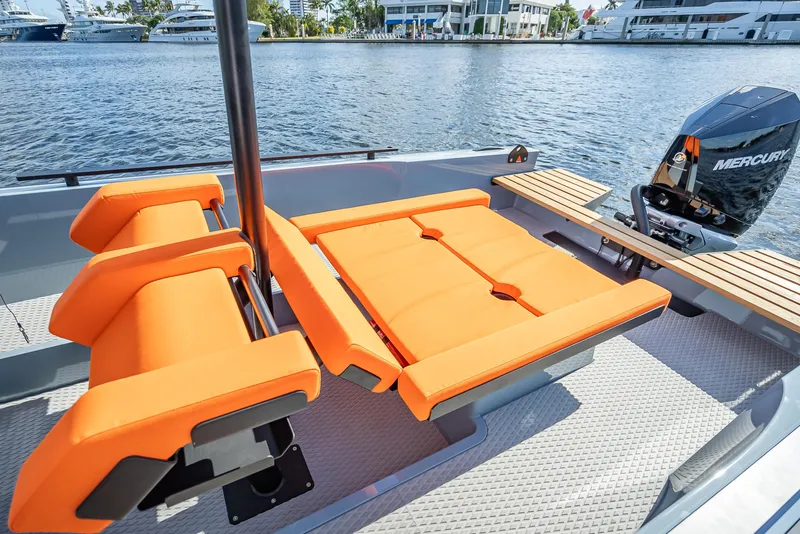 Slide: The Image of Goldfish 28 Tender 2024 with orange seating and Mercury outboard engine on water. - 12