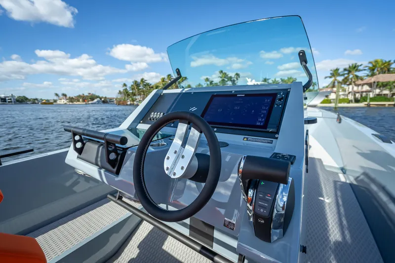 Slide: The Image of 2024 Goldfish 28 Tender boat dashboard with steering wheel and navigation system. - 20