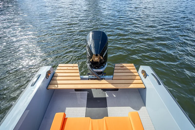 Slide: The Image of 2024 Goldfish 28 Tender boat stern with outboard motor on water. - 3