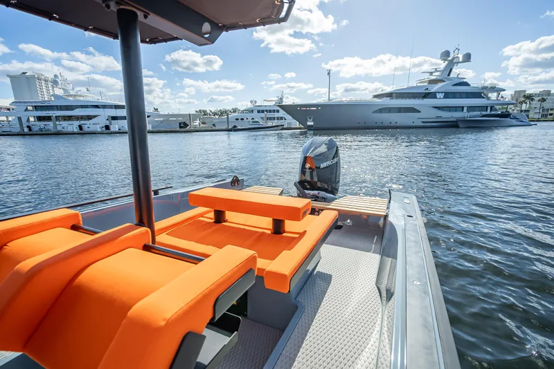 Slide: The Image of 2024 Goldfish 28 Tender boat with orange seats docked in a marina. - 6