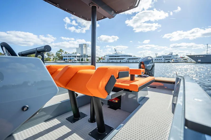 Slide: The Image of 2024 Goldfish 28 Tender boat with orange seating, docked at a marina. - 9