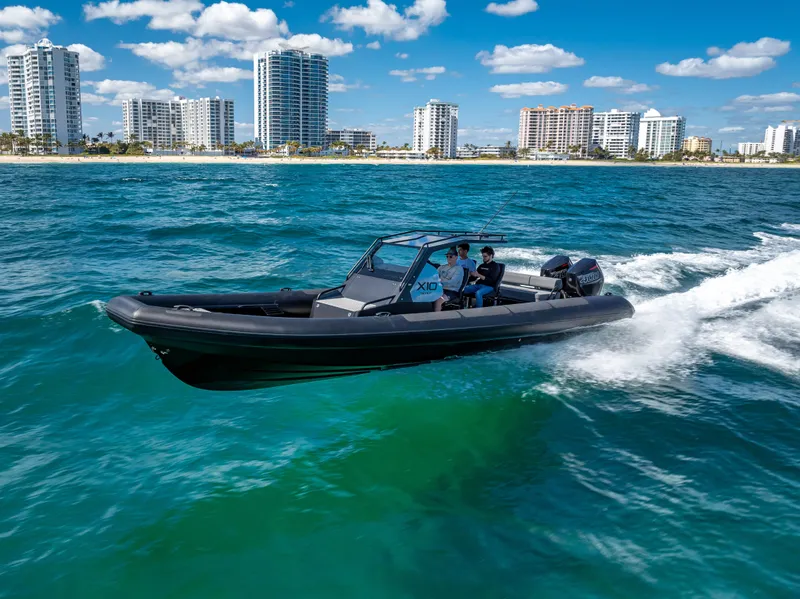 Slide: The Image of 2024 Goldfish X10 Scout boat cruising on blue ocean near city skyline. - 18