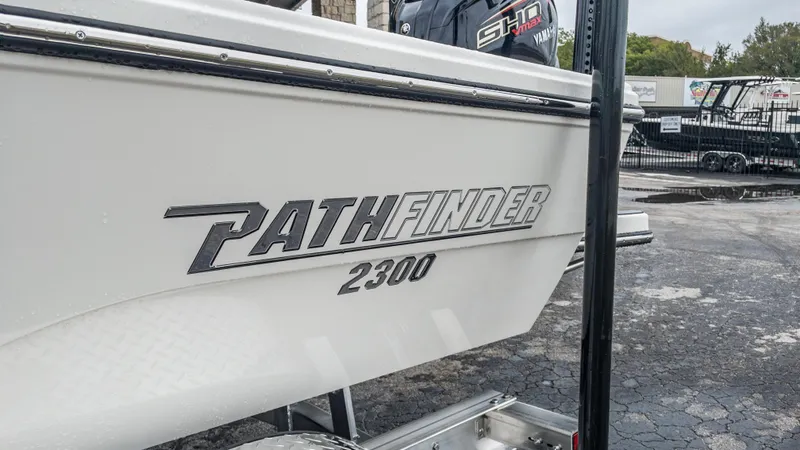 Slide: The Image of 2024 Pathfinder 2300 HPS boat side view with logo and Yamaha engine. - 13