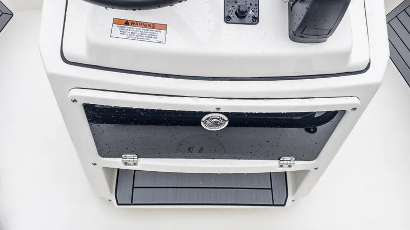 Slide: The Image of 2024 Pathfinder 2300 HPS boat console with storage compartment and warning label. - 24