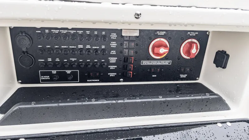 Slide: The Image of 2024 Pathfinder 2300 HPS boat control panel with switches and dials, wet with water droplets. - 25
