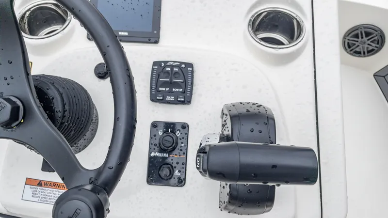 Slide: The Image of Close-up of the 2024 Pathfinder 2300 HPS boat control panel with steering wheel. - 8