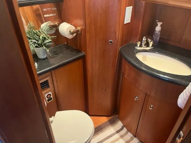 Slide: The Image of 2002 Silverton 39 Motor Yacht bathroom with wooden cabinetry and modern fixtures. - 14