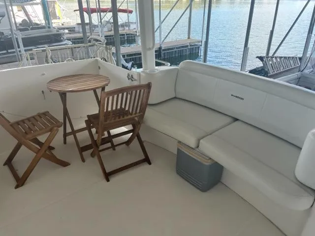 Slide: The Image of 2002 Silverton 39 Motor Yacht deck with seating area and wooden table. - 28
