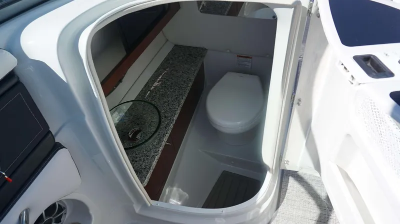 Slide: The Image of 2024 Crownline 290 XSS boat interior bathroom with granite countertop and modern toilet. - 11