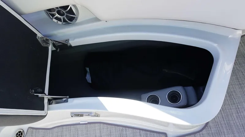 Slide: The Image of Storage compartment in 2024 Crownline 290 XSS boat with cup holders and speaker. - 12