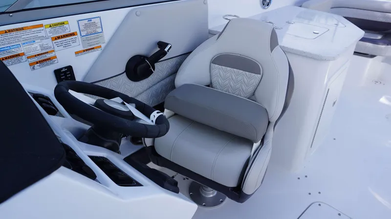 Slide: The Image of 2024 Hurricane 2690 SD boat cockpit with steering wheel and captain's chair. - 22
