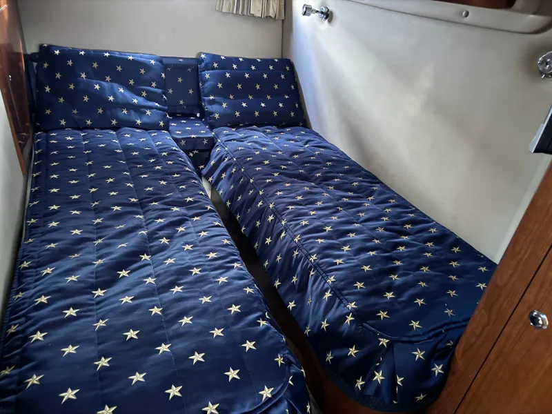 Slide: The Image of Twin beds with star-patterned bedding in a 2007 Regal 4060 COMMODORE yacht cabin. - 24