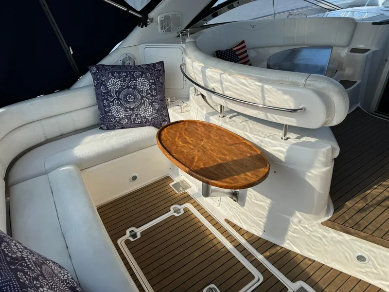Slide: The Image of 2007 Regal 4060 Commodore yacht interior with white seating and wooden table. - 7