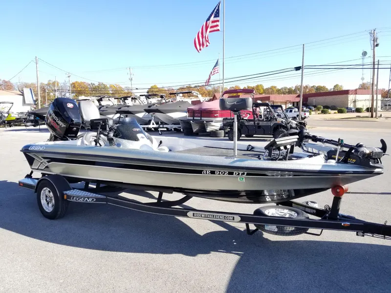 Slide: The Image of 2014 Legend Boats ALPHA 191 SCX on trailer, displayed outdoors with American flag in background. - 2