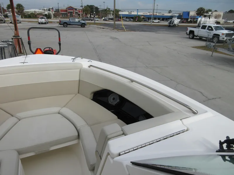 Slide: The Image of 2021 Boston Whaler 280 Vantage boat interior with beige seating at a marina. - 13