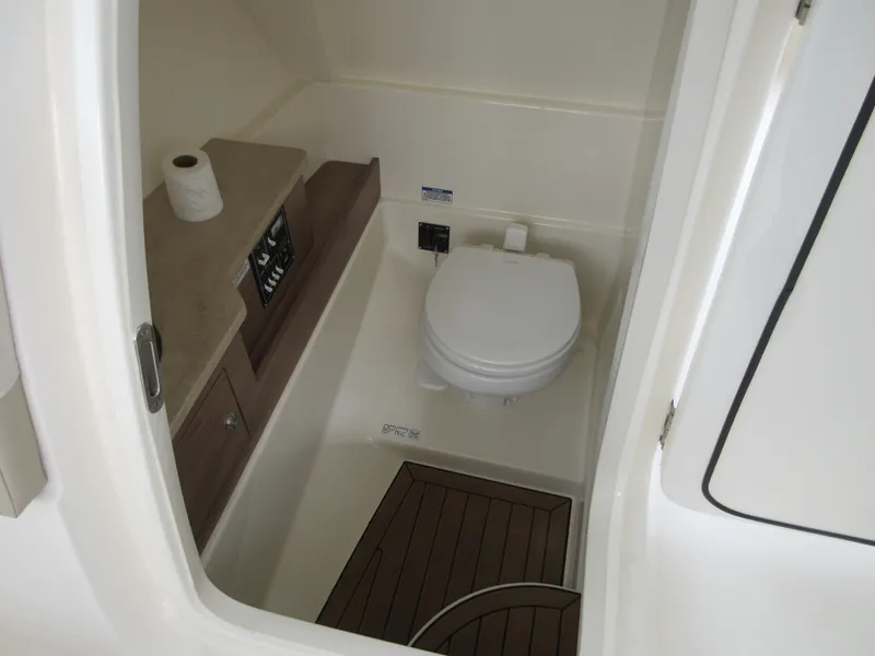 Slide: The Image of 2021 Boston Whaler 280 Vantage boat interior bathroom with toilet and wooden flooring. - 16