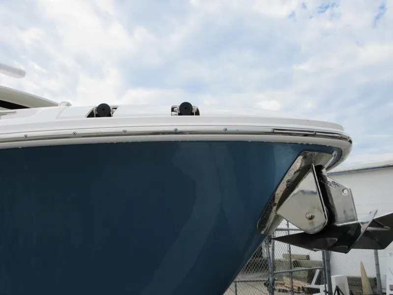 Slide: The Image of 2021 Boston Whaler 280 Vantage boat bow with anchor under cloudy sky. - 24