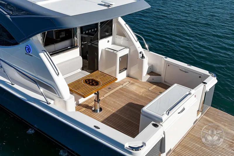 Slide: The Image of 2026 Riviera 395 SUV yacht with elegant deck and seating area on the water. - 15