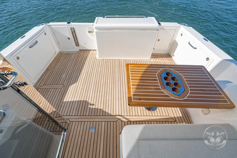 Slide: The Image of 2026 Riviera 395 SUV yacht deck with elegant wood table and ocean view. - 16