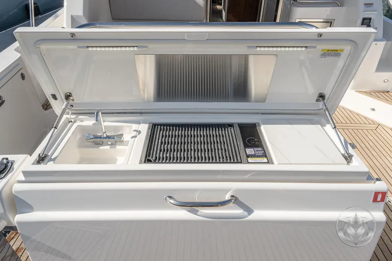 Slide: The Image of Outdoor kitchen on 2026 Riviera 395 SUV yacht with sink and grill. - 17