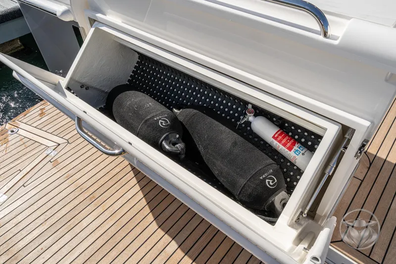 Slide: The Image of Storage compartment on 2026 Riviera 395 SUV yacht with fenders and fire extinguisher. - 18