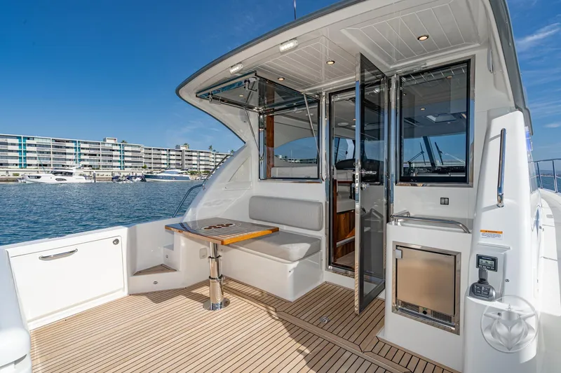 Slide: The Image of 2026 Riviera 395 SUV yacht deck with seating, table, and waterfront view. - 19