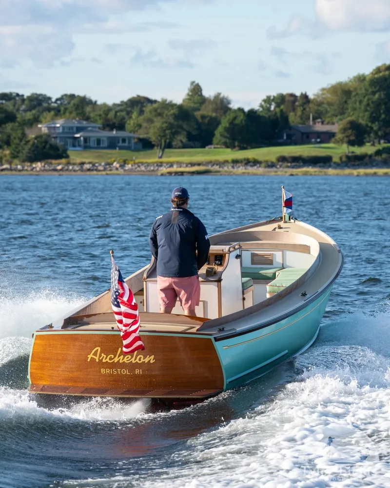 Slide: The Image of 2021 Center Console East Passage 24 boat cruising on water with American flag. - 13