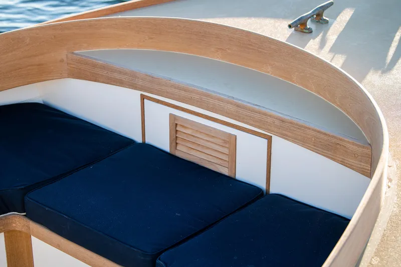 Slide: The Image of 2021 Center Console East Passage 24 boat seating area with blue cushions and wooden trim. - 15