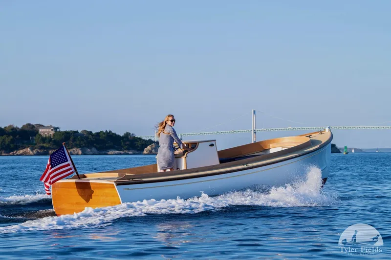 Slide: The Image of Woman piloting 2021 East Passage 24 Center Console boat on calm water. - 5