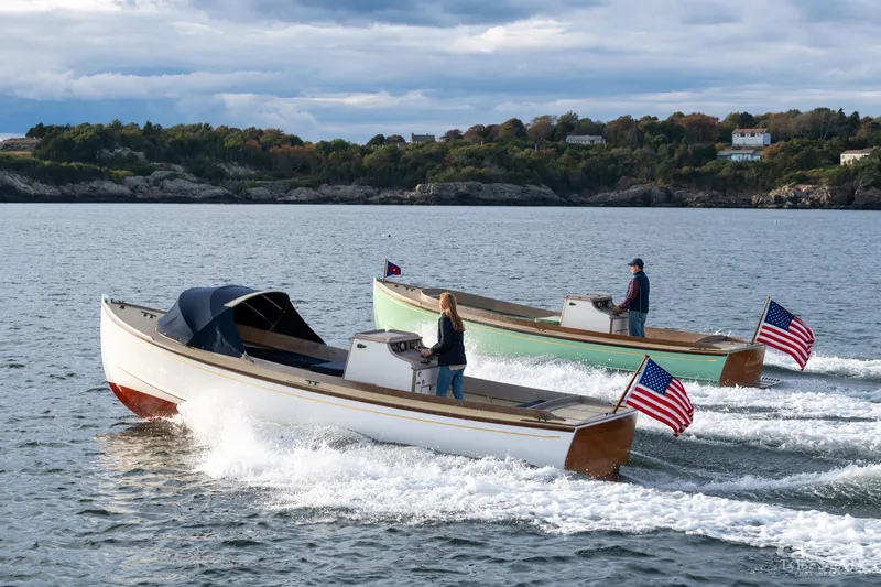 Slide: The Image of Two 2021 East Passage 24 Center Console boats cruising on a scenic lake. - 7