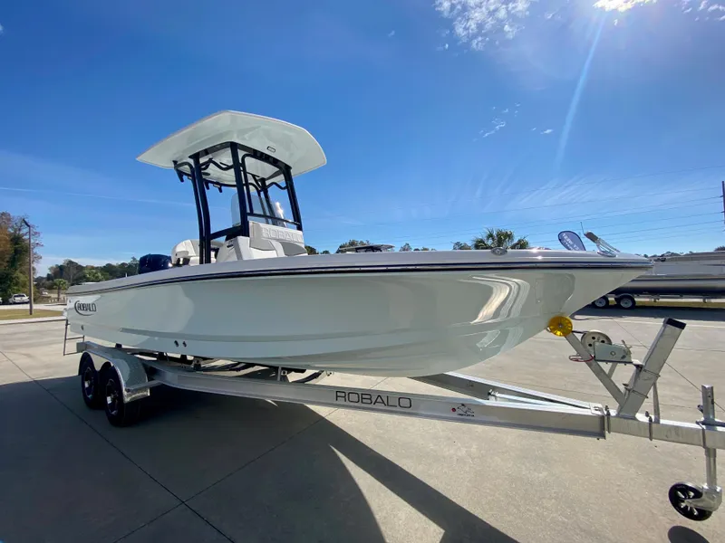 Slide: The Image of 2024 Robalo 226 Cayman boat on trailer under clear blue sky. - 3