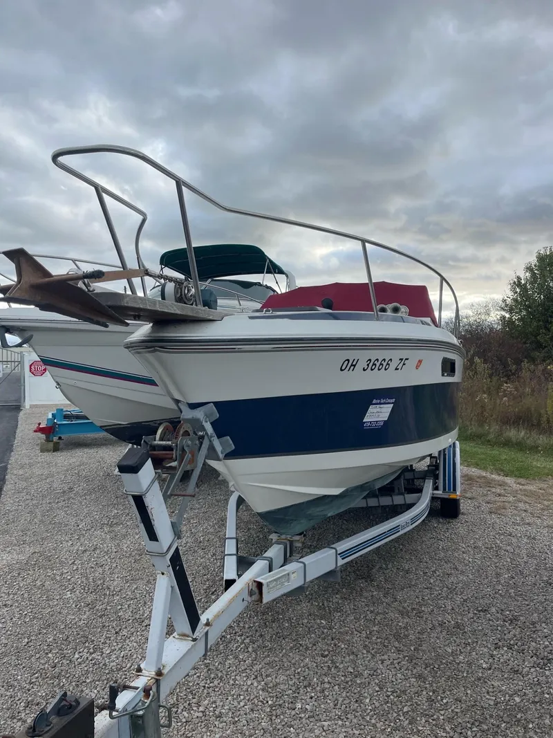 Slide: The Image of 1988 Regal boat on trailer under cloudy sky. - 2