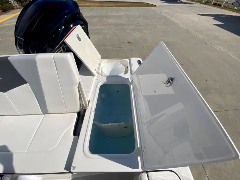 Slide: The Image of 2024 Robalo 226 Cayman boat with open storage compartments and seating. - 10