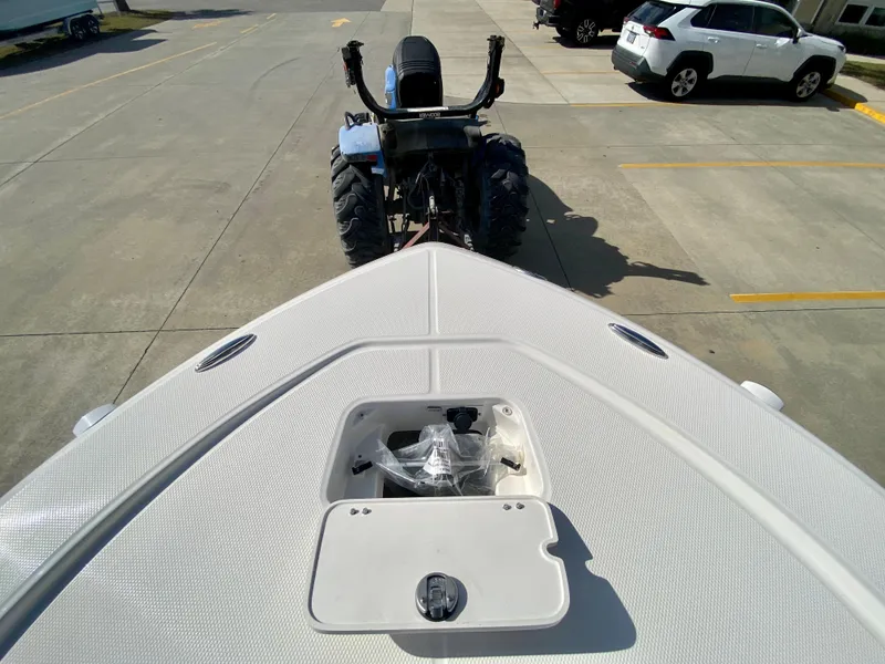 Slide: The Image of 2024 Robalo 226 Cayman boat bow view with storage compartment, parked on a trailer. - 24