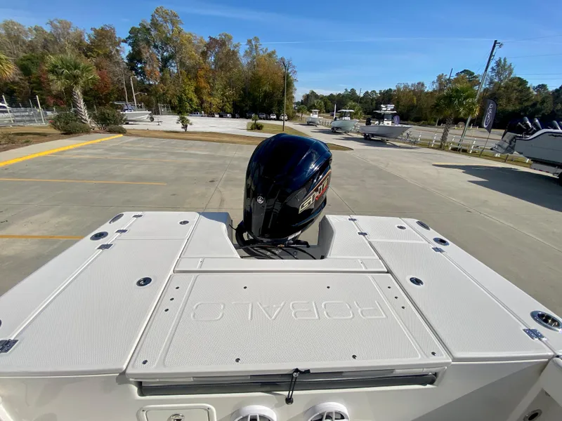 Slide: The Image of 2024 Robalo 226 Cayman boat with outboard motor in a parking lot. - 6