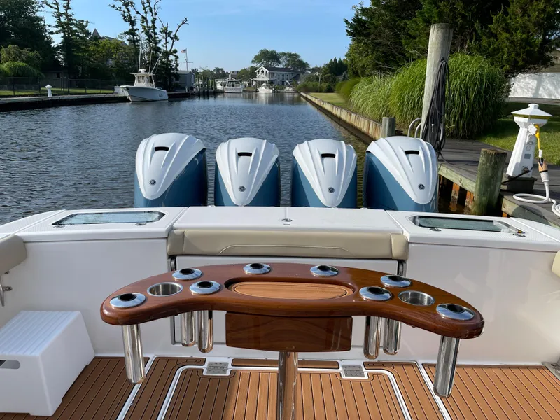 Slide: The Image of 2019 Everglades 435 CC boat with four engines docked on a serene canal. - 10